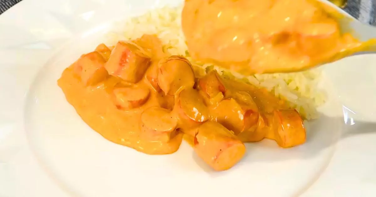 Strogonoff de salsicha servido com arroz e batata palha.