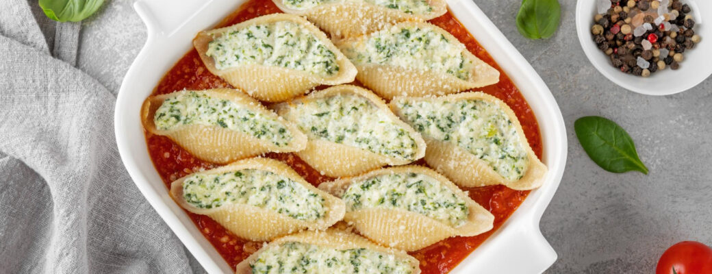 O Conchiglione Recheado é Uma Opção Perfeita Para Quem Busca Um Prato Saboroso E Sofisticado. Seu Formato De Concha Permite Recheios Variados, Tornando-o Versátil Para Diferentes Ocasiões. Como Surgiu O Conchiglione? O Conchiglione Tem Origem Italiana, Sendo Uma Das Diversas Variedades De Massas Desenvolvidas Na Região Da Campânia. Seu Nome Vem Do Italiano "conchiglia", Que Significa Concha, Remetendo Ao Seu Formato Característico. Tradicionalmente, Ele é Servido Recheado E Gratinado, Com Molhos Que Variam Entre Tomate E Bechamel. Quantas Calorias Tem O Conchiglione? As Calorias Do Conchiglione Variam Conforme O Recheio E O Molho Utilizado. Em Média, Uma Porção De 200g De Conchiglione Recheado Com Queijo E Molho De Tomate Possui Cerca De 350 A 450 Calorias. Informações Nutricionais Da Receita E Rendimento Tipo De Receita: Massa Recheada Tempo De Preparo: 30 Minutos Tempo De Forno: 20 Minutos Tempo Total: 50 Minutos Rendimento: 4 Porções Calorias Por Porção: Aproximadamente 400 Kcal Ingredientes 300g De Conchiglione (massa Em Formato De Concha) 250g De Ricota (para Um Recheio Cremoso) 100g De Espinafre Cozido E Picado (opcional, Para Um Toque Mais Saudável) 200g De Queijo Muçarela Ralado (para Gratinar) 50g De Parmesão Ralado (para Um Sabor Extra) 1 Ovo (para Dar Liga Ao Recheio) 500ml De Molho De Tomate (para Cobrir E Deixar Suculento) 2 Colheres De Sopa De Azeite De Oliva (para Refogar) 2 Dentes De Alho Picados (para Temperar) Sal E Pimenta-do-reino A Gosto (para Ajustar O Sabor) Equipamentos Necessários Panela Grande Para Cozinhar A Massa Assadeira Para Levar Ao Forno Frigideira Para Refogar O Espinafre (se Utilizar) Tigela Para Misturar O Recheio Modo De Preparo 1. Cozinhando A Massa Ferva água Com Sal E Cozinhe O Conchiglione Até Ficar Al Dente. Escorra E Reserve. 2. Preparando O Recheio Misture A Ricota, O Espinafre, O Ovo, Metade Da Muçarela E Tempere Com Sal E Pimenta. 3. Montagem Do Prato Recheie Cada Conchiglione Com A Mistura De Ricota E Espinafre. Distribua-os Em Uma Assadeira Coberta Com Molho De Tomate. 4. Finalização E Forno Cubra Com Mais Molho De Tomate, Polvilhe Muçarela E Parmesão. Leve Ao Forno Preaquecido A 180ºC Por 20 Minutos Até Gratinar. Dicas Extras Experimente Outros Recheios Como Frango Com Catupiry Ou Carne Moída Com Requeijão. Para Um Toque Gourmet, Adicione Nozes Picadas Ao Recheio De Ricota. Sugestões De Acompanhamento O Conchiglione Recheado Combina Perfeitamente Com: Salada Verde Com Molho Balsâmico Pão Italiano Crocante Vinho Tinto Leve, Como Merlot Ou Pinot Noir Como Armazenar Geladeira: Armazene Em Recipiente Fechado Por Até 3 Dias. Freezer: Congele Por Até 2 Meses, Descongelando Na Geladeira Antes De Reaquecer. Reaquecimento: Use O Forno A 180ºC Por 15 Minutos Ou Micro-ondas Por 2 Minutos. Considerações Finais O Conchiglione Recheado é Uma Receita Fácil, Saborosa E Perfeita Para Impressionar Em Qualquer Ocasião. Experimente E Surpreenda-se! FAQs Posso Usar Outro Tipo De Queijo? Sim! Cottage, Cream Cheese Ou Queijo Minas Também Funcionam Bem. Qual é O Melhor Molho Para Acompanhar? Molho De Tomate é O Mais Usado, Mas Molho Branco Também é Uma ótima Opção. Posso Fazer A Receita Sem Forno? Sim! Basta Aquecer No Micro-ondas Até O Queijo Derreter. O Conchiglione Pode Ser Feito Com Recheio Vegano? Sim! Substitua Os Queijos Por Tofu Temperado E Use Molho De Castanhas. Qual Vinho Harmoniza Melhor Com Esse Prato? Tintos Leves Como Merlot Ou Chianti Combinam Muito Bem.